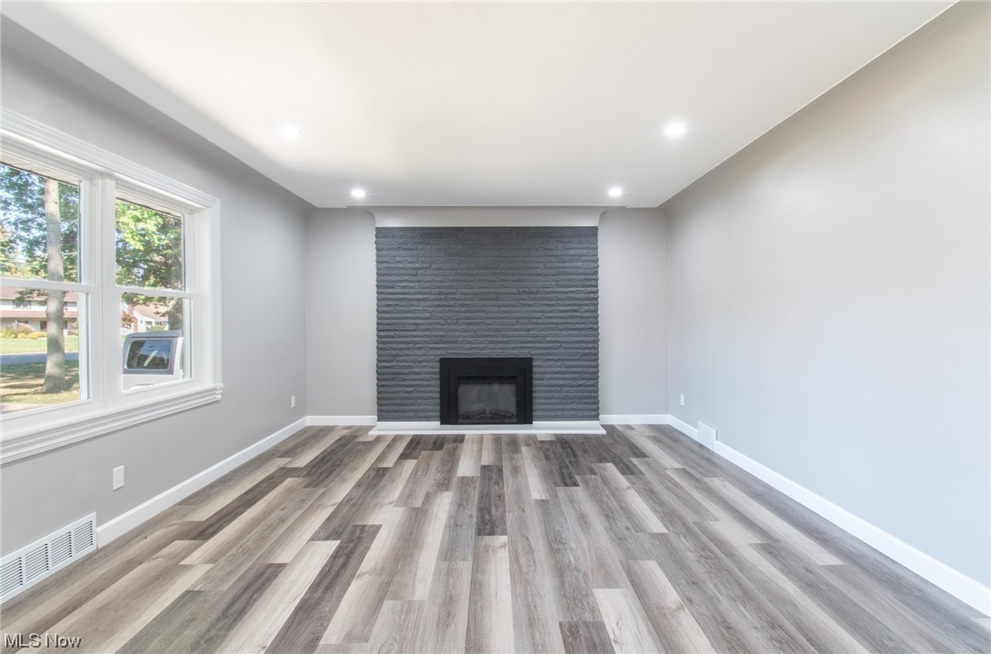 1097 South Meridian Road Youngstown, OH 44511 - Photo 9 of 29 Unfurnished living room with light hardwood flooring and a large fireplace