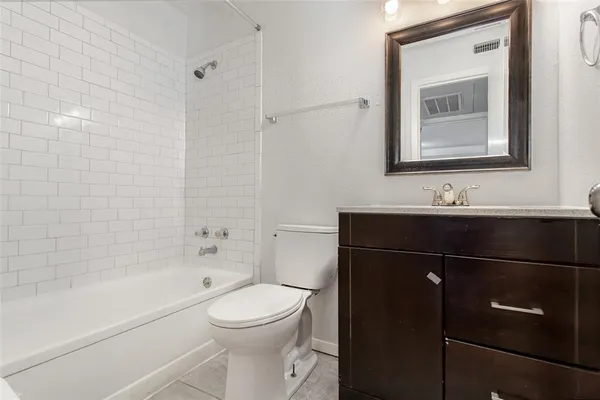 a bathroom with a bathtub sink vanity and toilet
