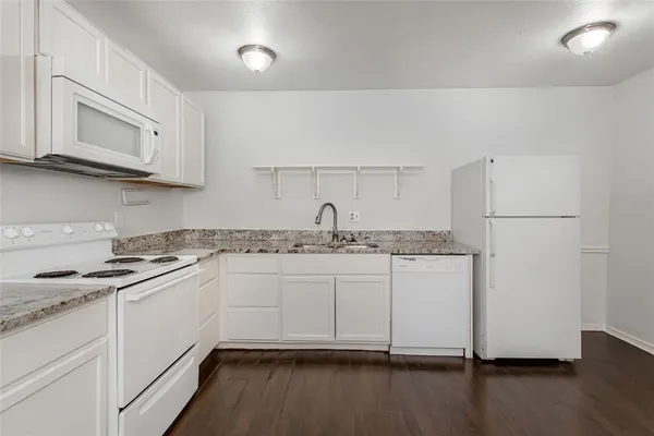 a kitchen with granite countertop a sink and cabinets