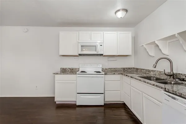 a kitchen with stainless steel appliances granite countertop a stove and white cabinets