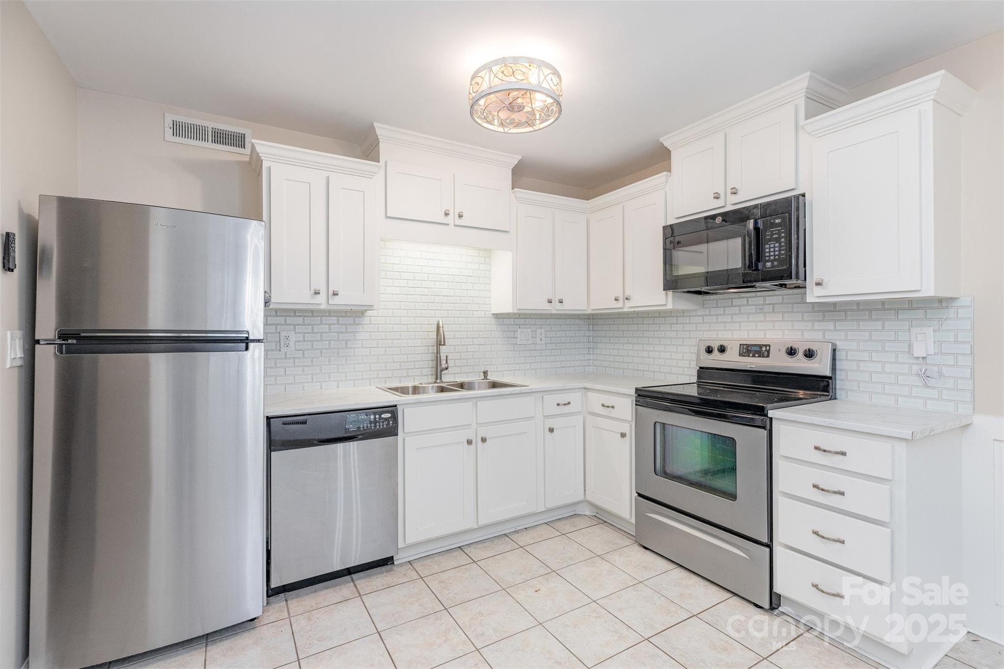 a kitchen with cabinets stainless steel appliances and a sink