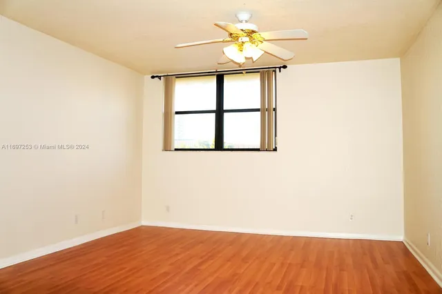a view of a room with wooden floor and a window