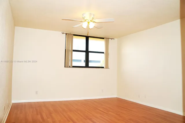an empty room with a window and a ceiling fan