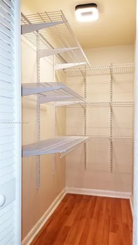 a view of a room with wooden floor and white walls