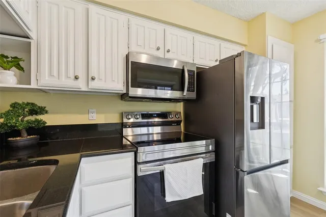 a kitchen with appliances a counter space and cabinets
