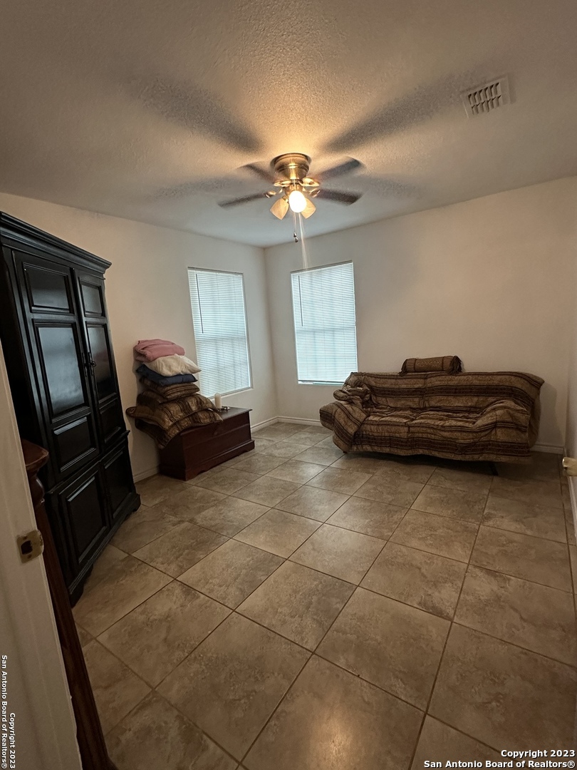 429 Wingate Street La Pryor, TX 78872 - Photo 5 of 14 a living room with a bed furniture a chandelier and a window