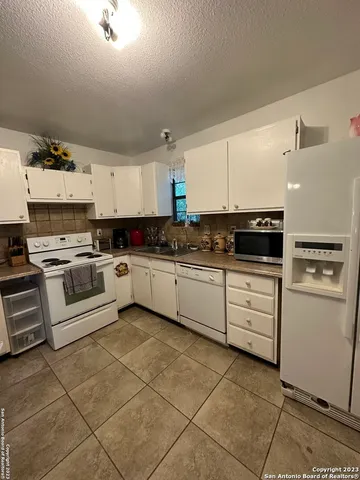 a kitchen with stainless steel appliances and white cabinets