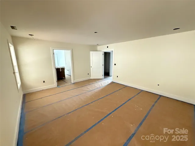 a view of empty room with window and wooden floor