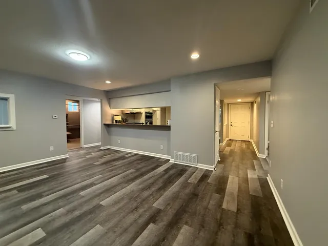 a view of empty room with wooden floor