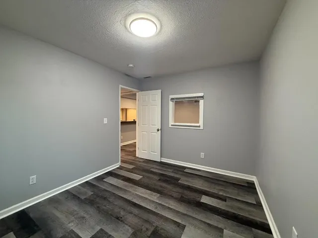 a view of room with window and wooden floor