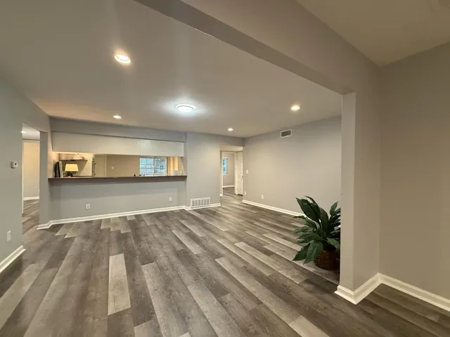 a view of empty room with wooden floor