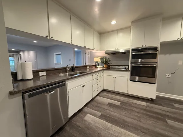 a kitchen with granite countertop a refrigerator and a sink