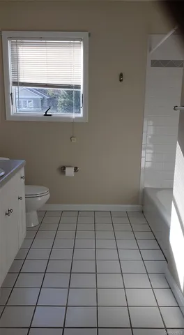 a bathroom with a sink toilet and window