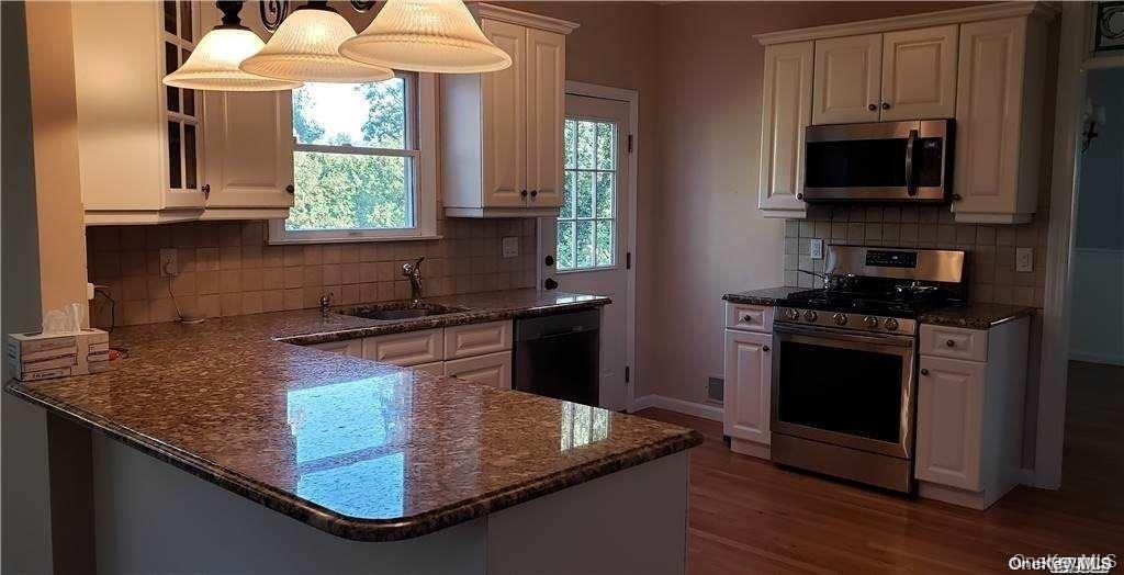 28 Carley Avenue Huntington, NY 11743 - Photo 5 of 17 a kitchen with stainless steel appliances granite countertop a sink a stove and a microwave
