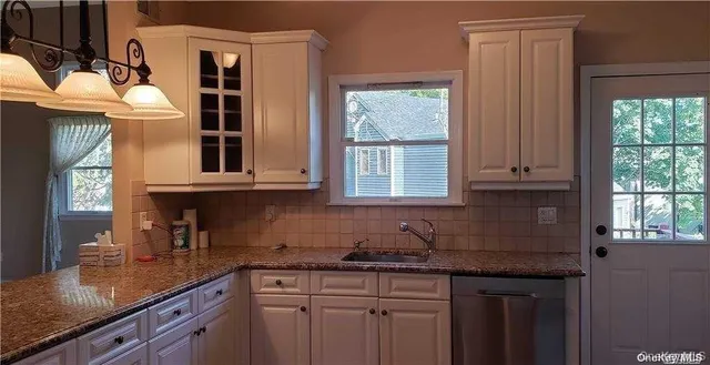 a kitchen with stainless steel appliances granite countertop a sink and a window