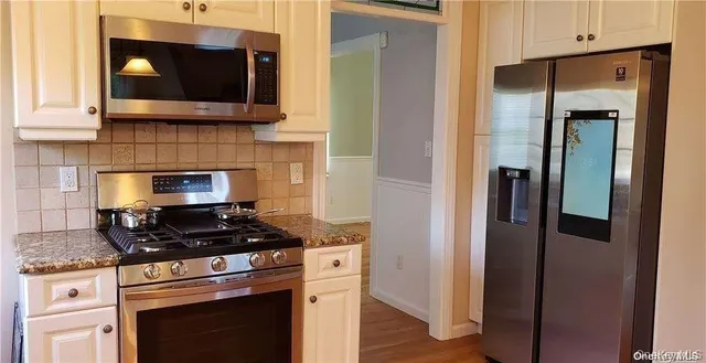 a kitchen with stainless steel appliances granite countertop a stove and a microwave