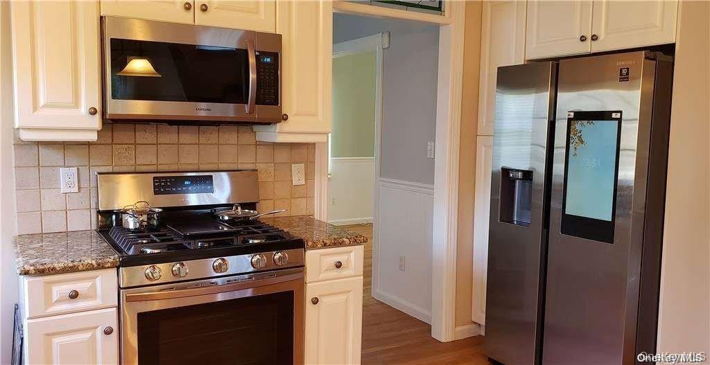 28 Carley Avenue Huntington, NY 11743 - Photo 7 of 17 a kitchen with stainless steel appliances granite countertop a stove and a microwave