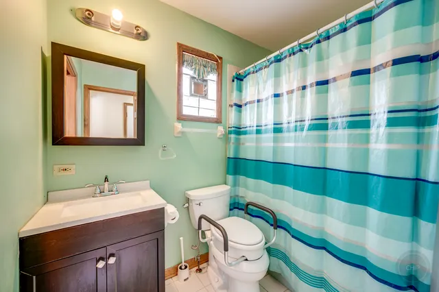 a bathroom with a sink a toilet and shower curtain