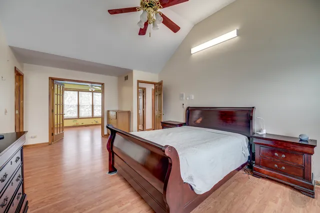 a bedroom with a bed and wooden floor