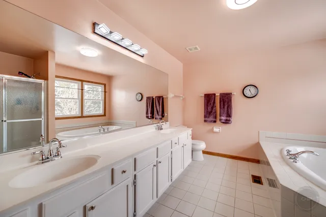 a bathroom with a double vanity sink a mirror and a bathtub