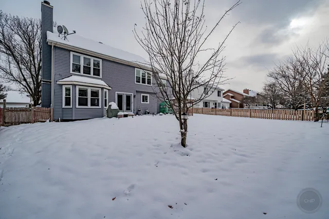 a front view of a house with a yard covered in snow
