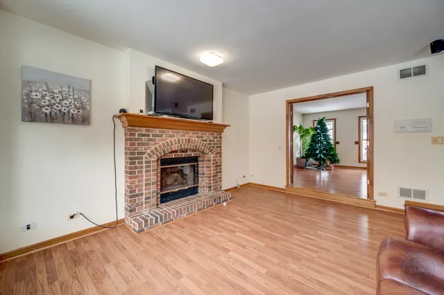 a view of empty room with floor to ceiling window and fireplace