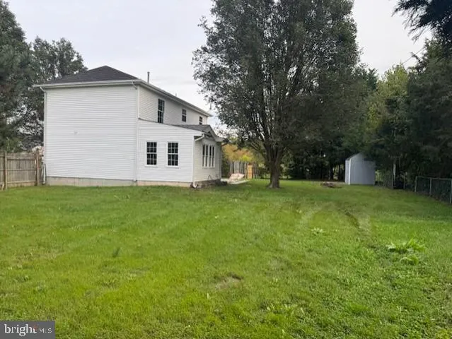 a white house that has a big yard with wooden fence
