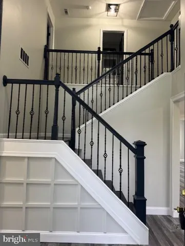 a view of staircase with railing and white walls