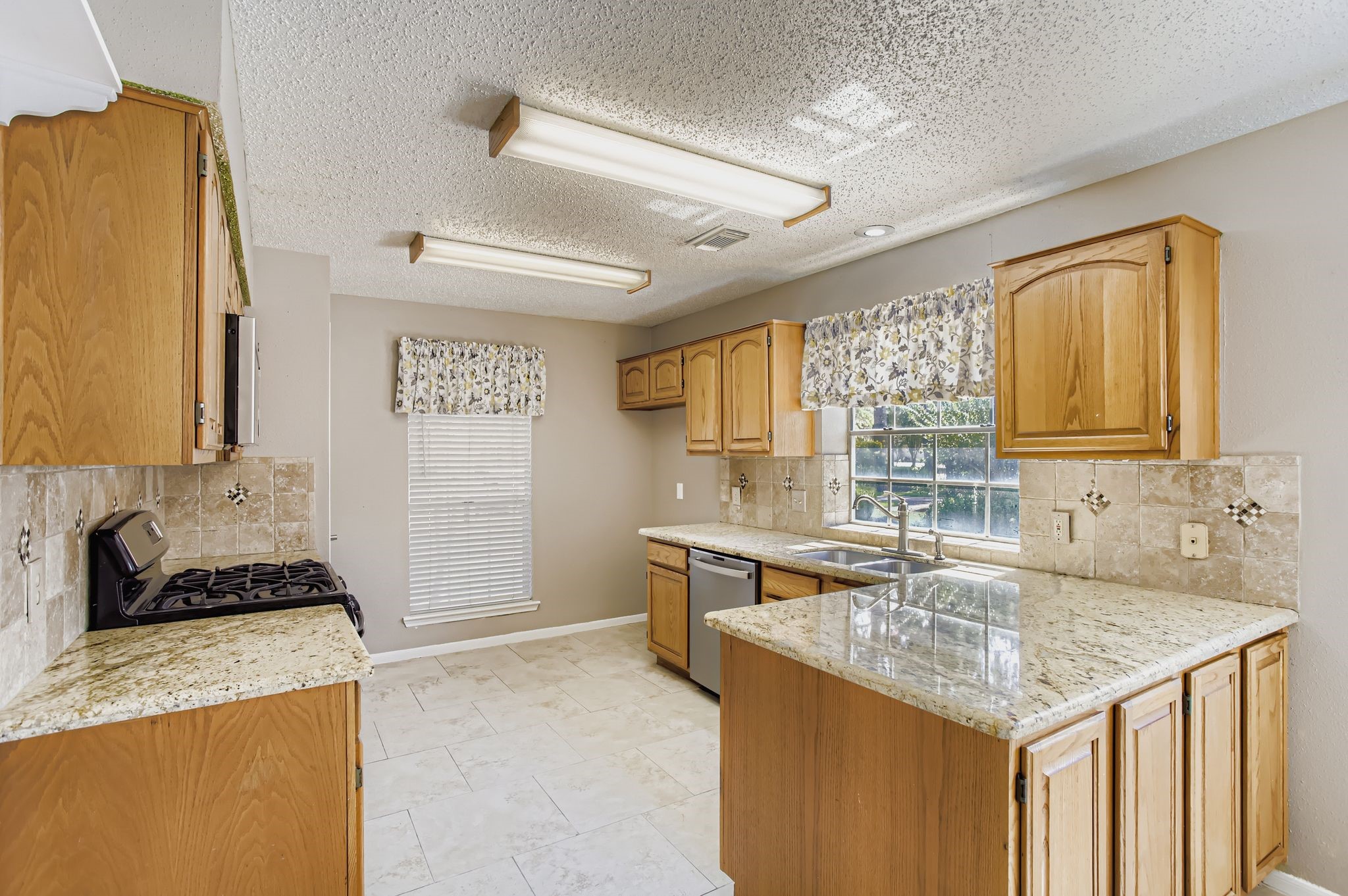 7519 Sunlight Lane Houston, TX 77095 - Photo 11 of 27 a kitchen with granite countertop a sink and a stove