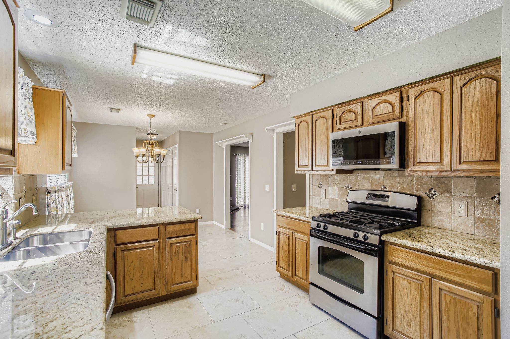 7519 Sunlight Lane Houston, TX 77095 - Photo 12 of 27 a kitchen with stainless steel appliances granite countertop a stove and a sink