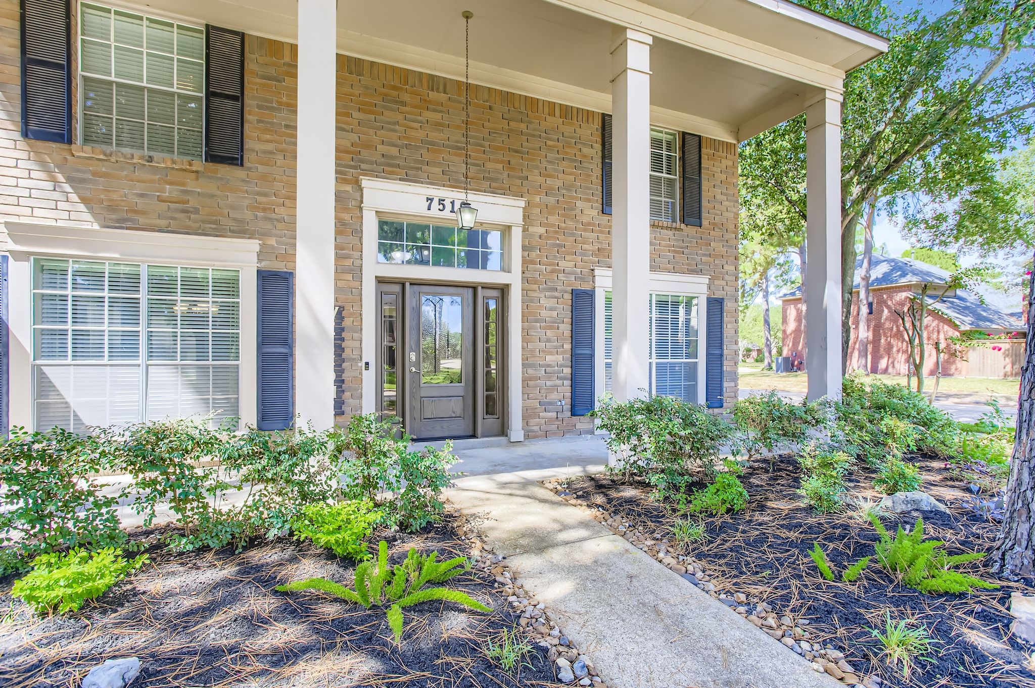 7519 Sunlight Lane Houston, TX 77095 - Photo 4 of 27 a view of a brick house with plants and large windows