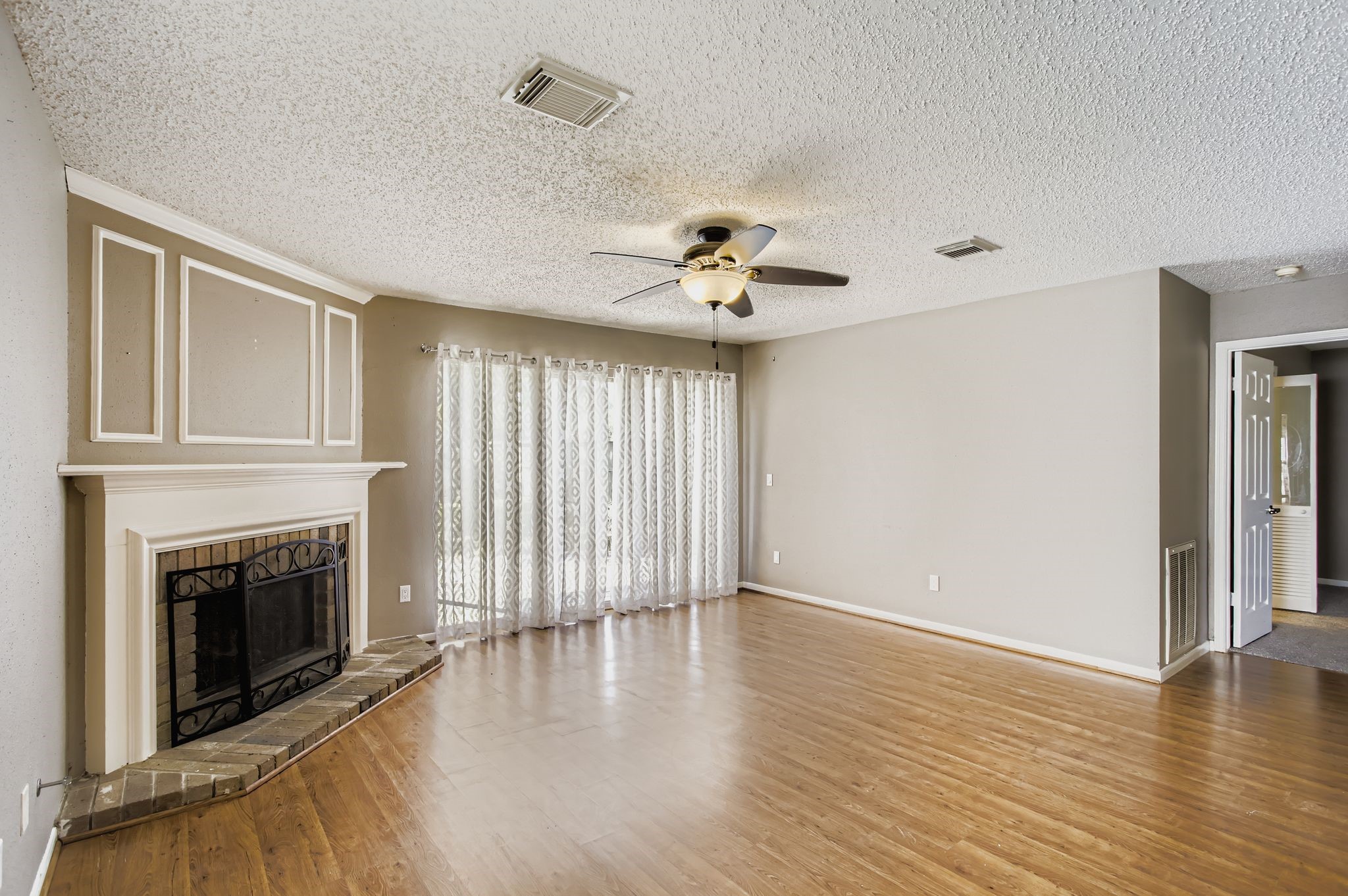 7519 Sunlight Lane Houston, TX 77095 - Photo 6 of 27 an empty room with wooden floor fireplace and windows