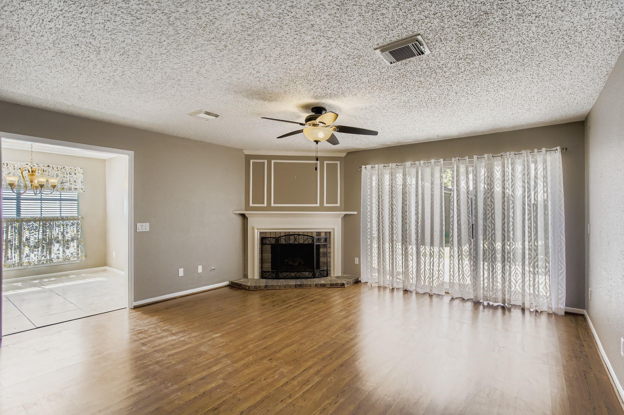 7519 Sunlight Lane Houston, TX 77095 - Photo 7 of 27 an empty room with wooden floor fireplace and windows