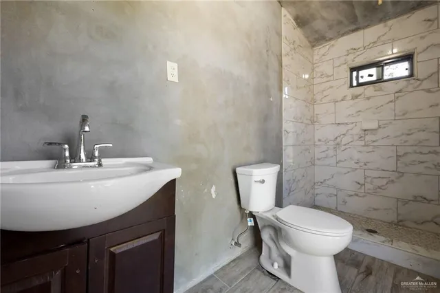 a bathroom with a toilet a sink and mirror