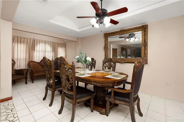 a view of a dining room with furniture and a chandelier fan