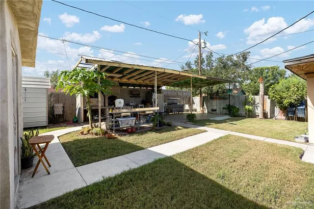 a view of a patio with a table and chairs under an umbrella