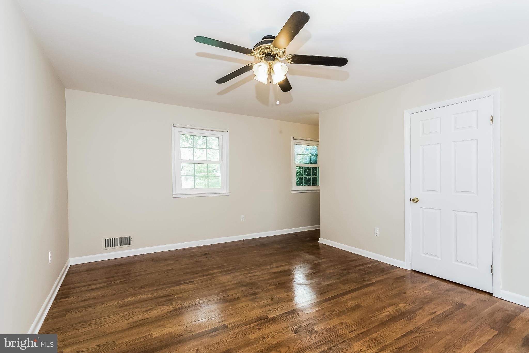 14517 Cobblestone Drive Silver Spring, MD 20905 - Photo 12 of 30 a view of an empty room with wooden floor and a ceiling fan