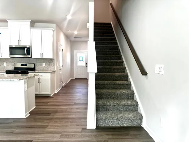 a view of an entryway with wooden floor and staircase