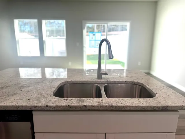 a kitchen with granite countertop a sink and a window