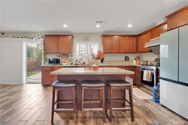 a kitchen with a dining table chairs refrigerator and cabinets