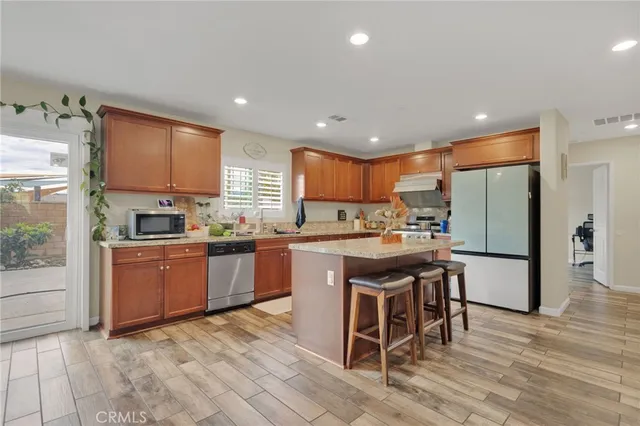 a kitchen with stainless steel appliances granite countertop a refrigerator and a stove top oven