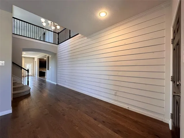 a view of a hallway with wooden floor and a ceiling fan