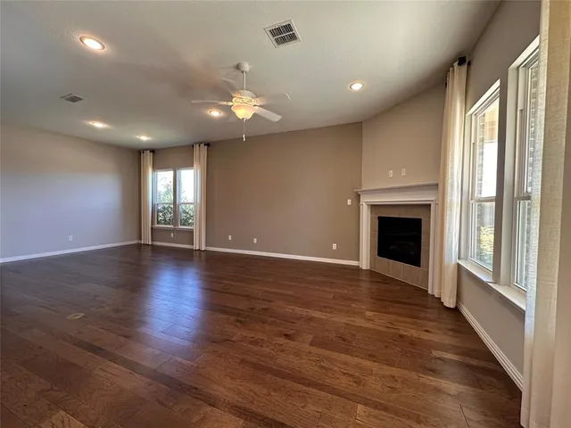 an empty room with wooden floor and fireplace
