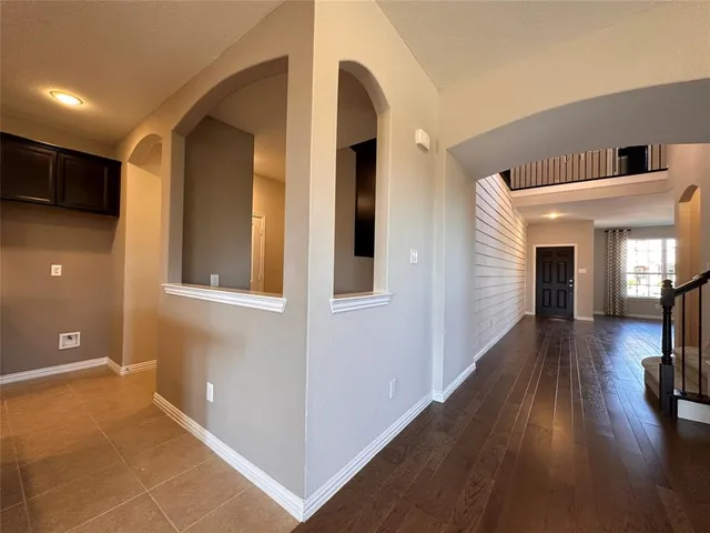 a view of a hallway view with wooden floor and living room