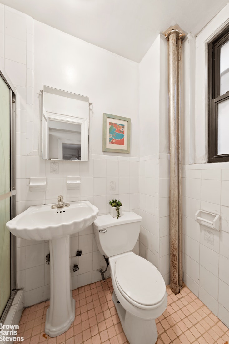 395 Riverside Drive, Unit 1E Manhattan, NY 10025 - Photo 4 of 7 a bathroom with a toilet sink and mirror