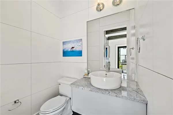 a bathroom with a granite countertop sink mirror vanity and toilet