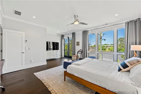 a bedroom with a large bed a flat tv screen and a dresser