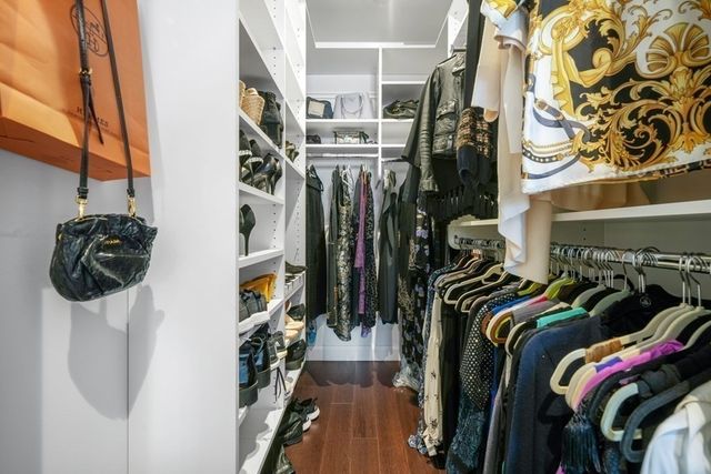a view of walk in closet with clothes and shoes