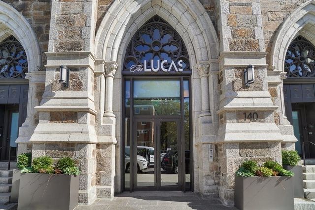 a front view of a building with a garden and plants