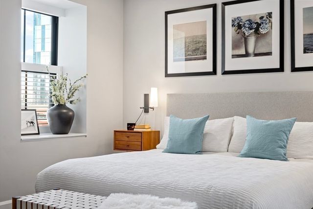 a bedroom with a bed and painting on the wall